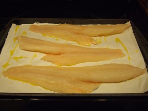 The fillets skin side down on the pan, drizzled with olive oil.