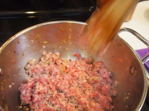 Breaking down the sausage while cooking.