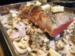 Place the roast on top of the mushrooms, shallots, herbs and garlic.  Then add three tablespoons of butter cubed all around the roast and the veggies below.