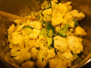 Mix the cauliflower and broccoli in the pot with the olive oil, and add 3 cups of water (shown at the bottom of the pan)