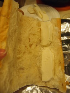 Shown: the bread with crumb removed and with a sprinkle of grated cheese and two slices of the mozzarella