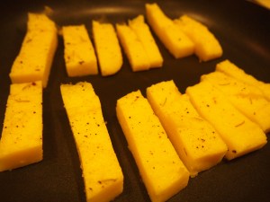In a dry non-stick pan, place cut pieces of polenta to brown.
