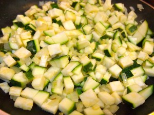 Zucchini combined with onion and garlic in skillet.