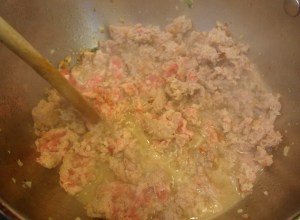 Break up the sausage with a wooden spoon to make the pieces smaller.