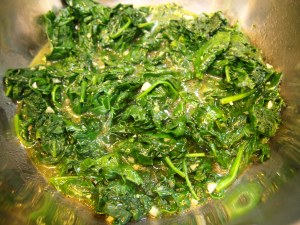 Spinach after being cooked.  Now set aside on a dish.
