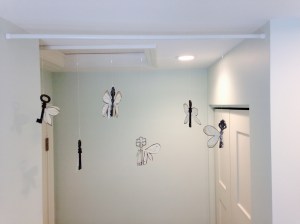 Strung them up with clear, stretchy jewelry thread.  Then hung them from a tension rod.  